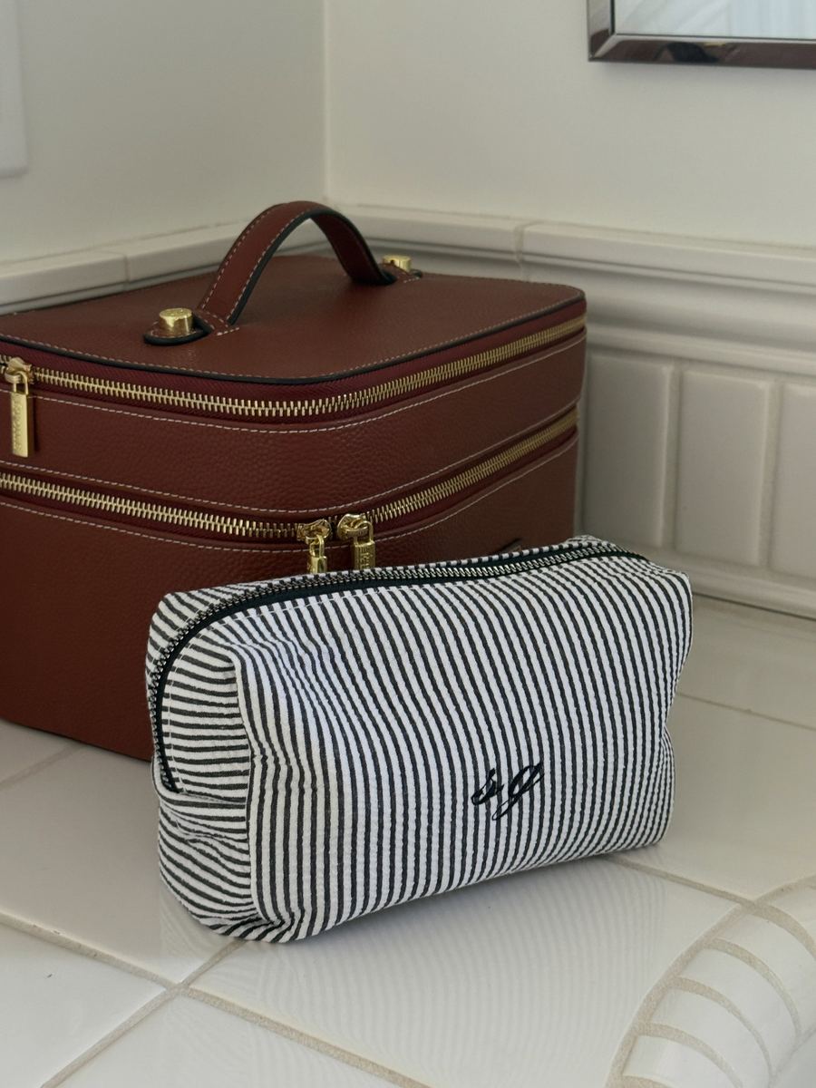 Black-and-white striped cosmetic bag with a small monogram