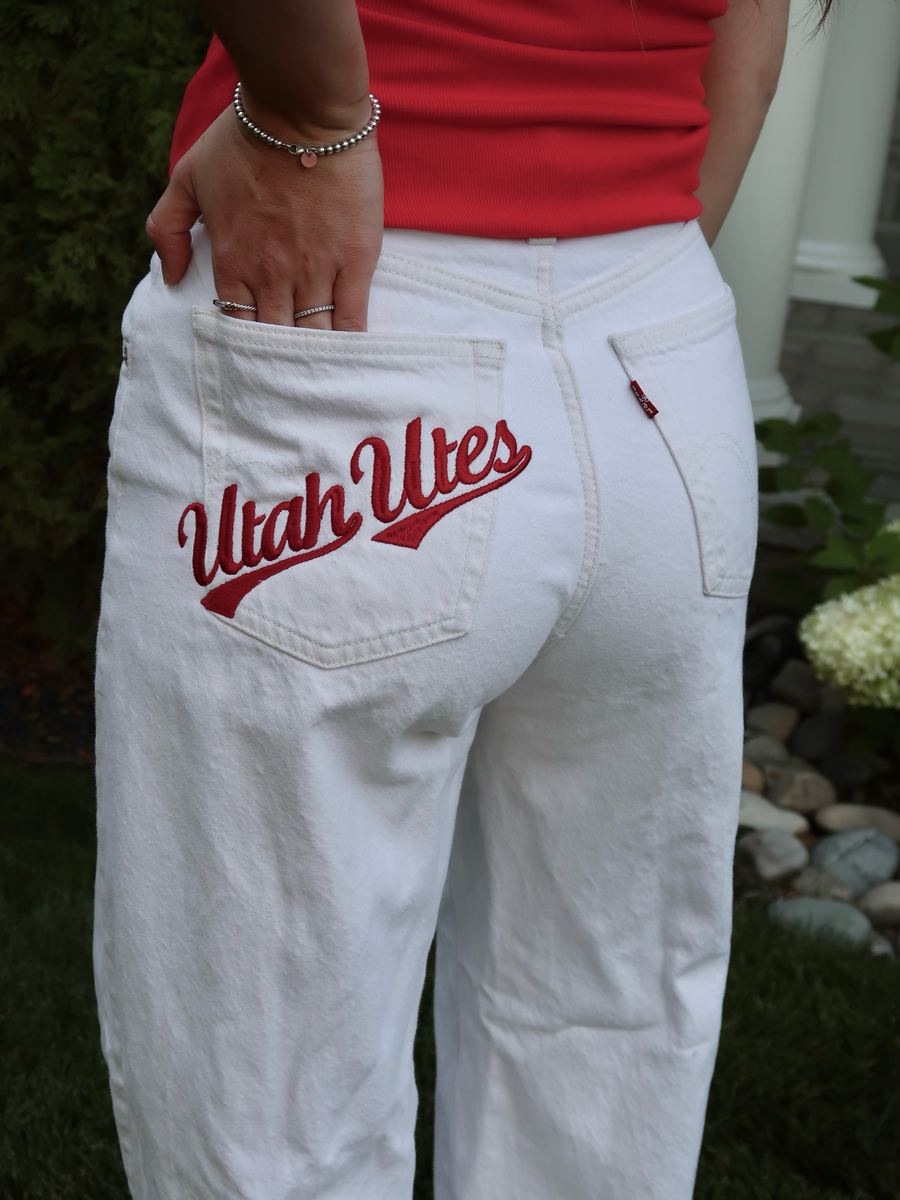 White jeans with red Utah Utes script embroidered on the back pocket